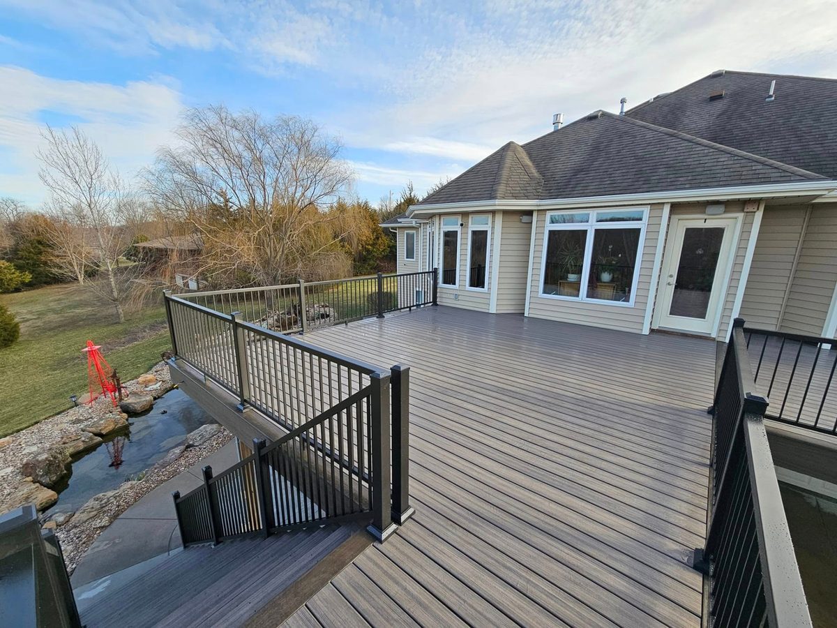 Elevated deck with custom stairs leading down to the concrete patio